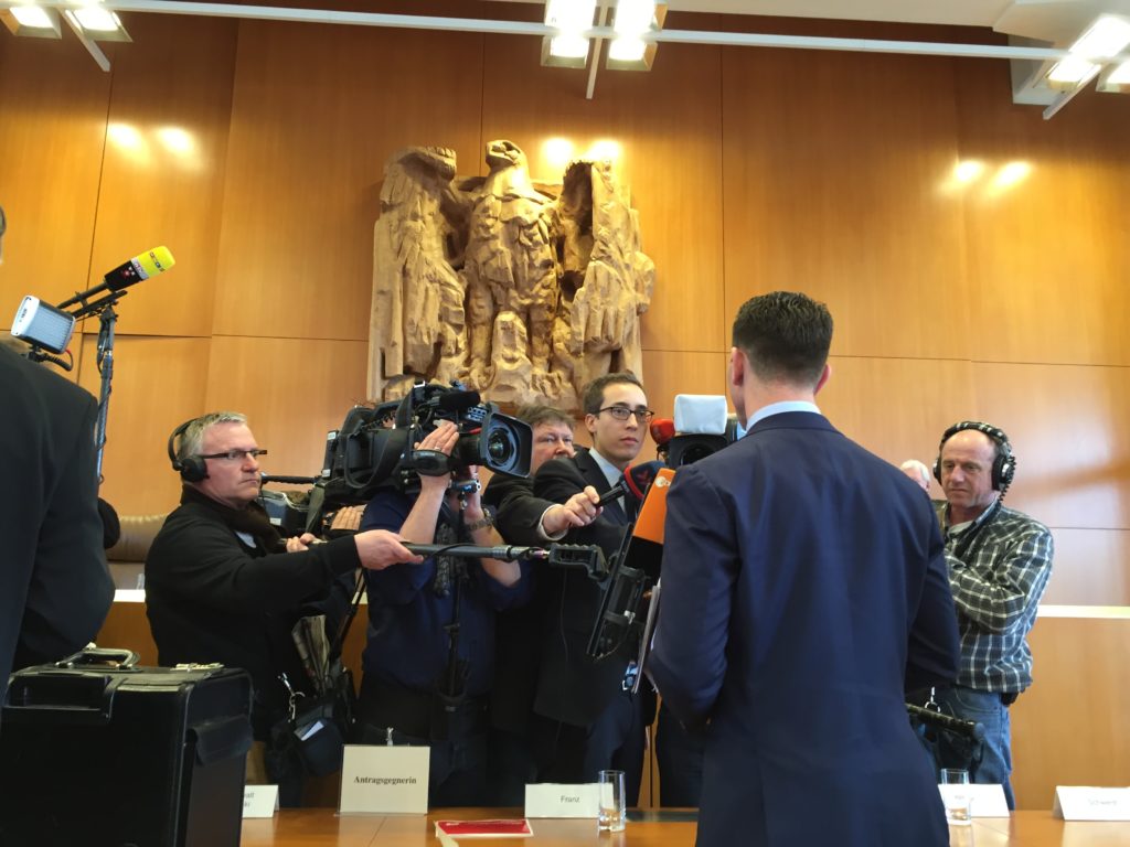  Franz [back to camera] Addresses Media in the Court’s Hearing Chamber